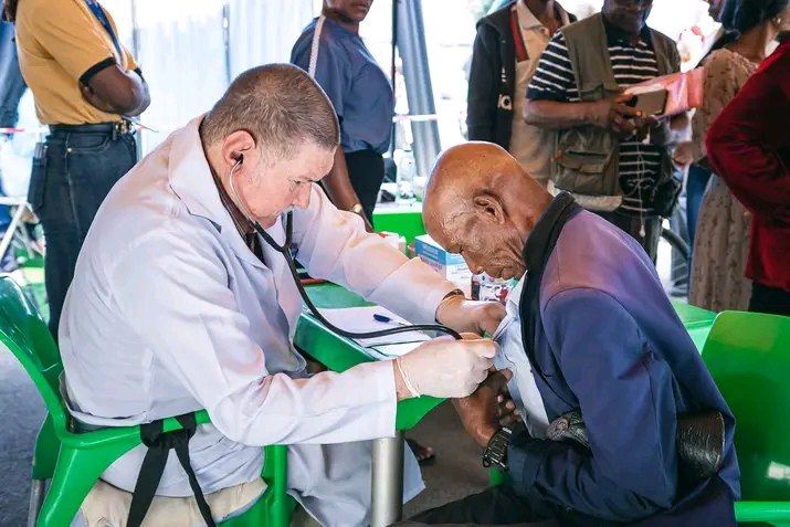 Médico a auscultar um paciente numa actividade ao ar livre